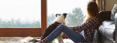 Lady with dog looking out window