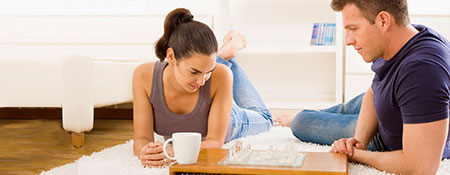 couple playing a game on the floor of a warm and bright house